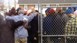 Brother Paul Holderfield, Jr. praying with soup kitchen friends